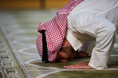 Dindar Müslüman adam caminin içinde dua ediyor.