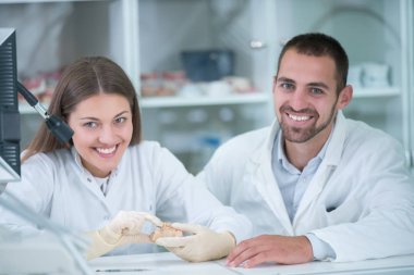 Takma diş, ağız hijyeni. Takma diş, takma diş, bir çalışma ve diş araçları içeren bir tablo üzerinde çalışırken protez eller.