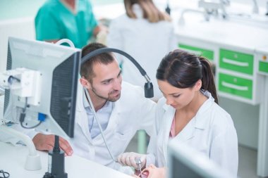 Takma diş, ağız hijyeni. Takma diş, takma diş, bir çalışma ve diş araçları içeren bir tablo üzerinde çalışırken protez eller.