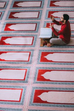 Dindar Müslüman adam caminin içinde dua ediyor.