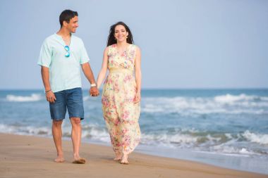 Kumsalda yürüyen çift.