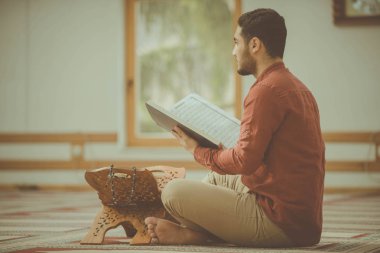 Dindar Müslüman adam caminin içinde dua ediyor.