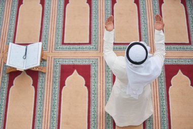 Dindar Müslüman adam caminin içinde dua ediyor.