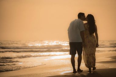 Kumsalda yürüyen çift.