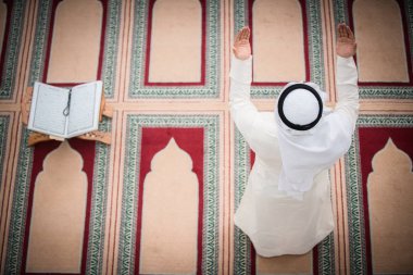 Dindar Müslüman adam caminin içinde dua ediyor.