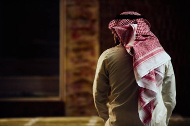 Dindar Müslüman adam caminin içinde dua ediyor.
