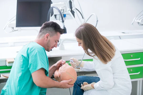 Takma diş, ağız hijyeni. Takma diş, takma diş, bir çalışma ve diş araçları içeren bir tablo üzerinde çalışırken protez eller.