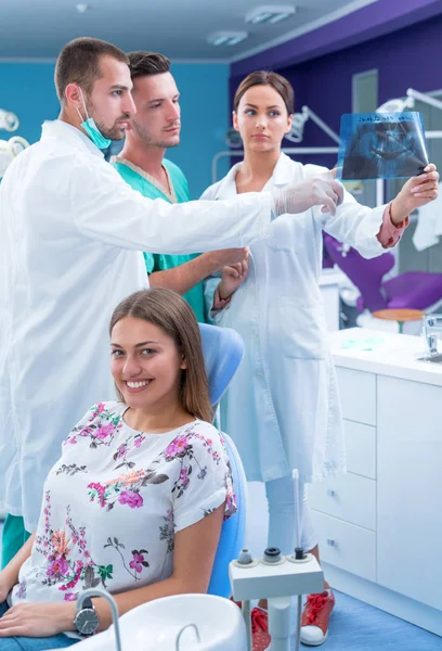 牙科医生在现代办公室里显示了病人的 — 图库照片