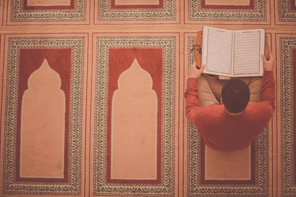 Dindar Müslüman adam caminin içinde dua ediyor.