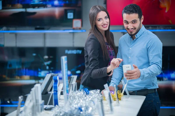 tüketici elektroniği genç bir çift satın almak en son dizüstü bilgisayar, televizyon ve fotoğraf kamera seyir saklamak