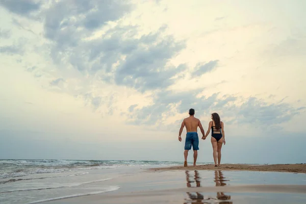 妊娠中のカップルは ビーチの上を歩く — ストック写真
