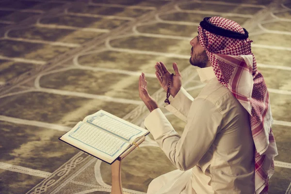 Dindar Müslüman adam caminin içinde dua ediyor.