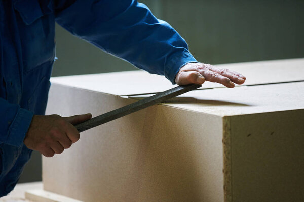 Young male worker  work in a factory for the production of furniture