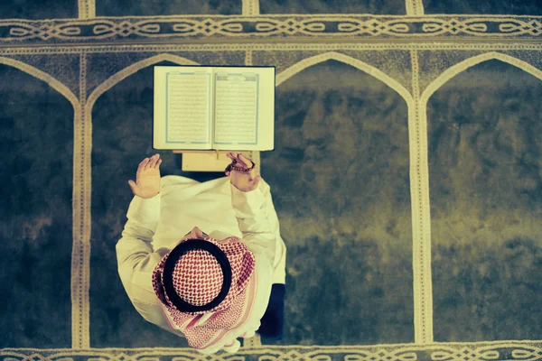 Dindar Müslüman adam caminin içinde dua ediyor.