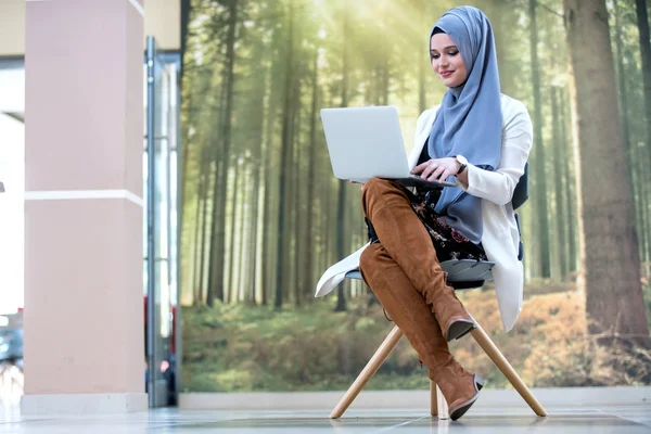 漂亮的女人戴头巾做办公室工作与笔记本电脑 — 图库照片