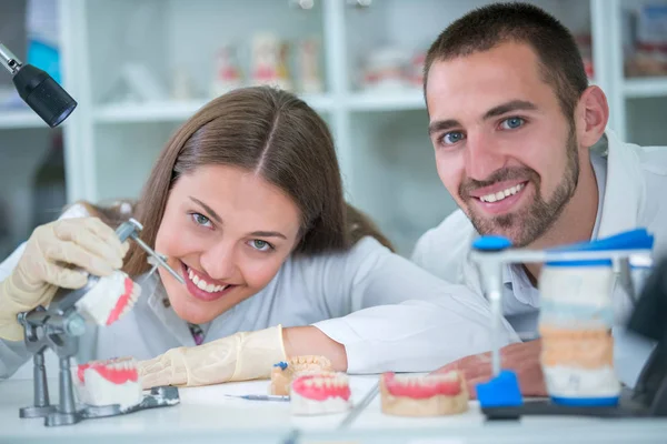 Takma diş, ağız hijyeni. Takma diş, takma diş, bir çalışma ve diş araçları içeren bir tablo üzerinde çalışırken protez eller.