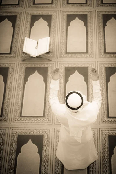 Dindar Müslüman adam caminin içinde dua ediyor.