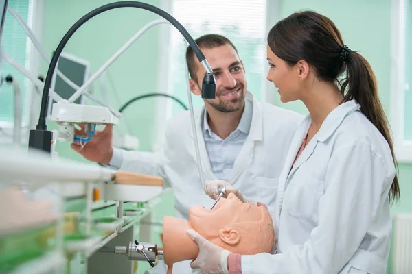 Takma diş, ağız hijyeni. Takma diş, takma diş, bir çalışma ve diş araçları içeren bir tablo üzerinde çalışırken protez eller.