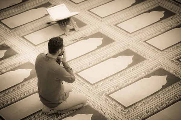Dindar Müslüman adam caminin içinde dua ediyor.