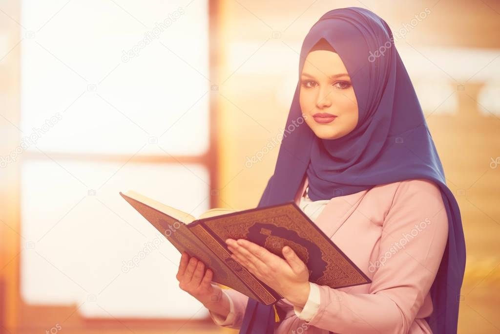 Young muslim woman praying in mosque