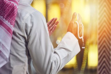 Dindar Müslüman adam caminin içinde dua ediyor.