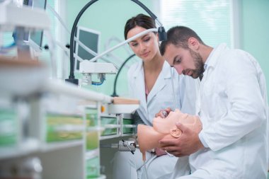 Takma diş, ağız hijyeni. Takma diş, takma diş, bir çalışma ve diş araçları içeren bir tablo üzerinde çalışırken protez eller.