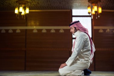 Dindar Müslüman adam caminin içinde dua ediyor.