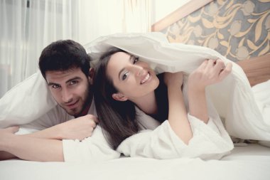 concept d'hôtel, voyages, relations et le bonheur - heureux couple au lit