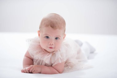 Odasındaki yatakta emekleyen bir bebeğin portresi.