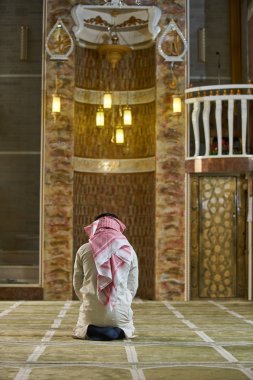 Dindar Müslüman adam caminin içinde dua ediyor.