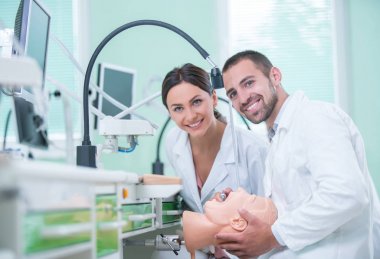 Takma diş, ağız hijyeni. Takma diş, takma diş, bir çalışma ve diş araçları içeren bir tablo üzerinde çalışırken protez eller.