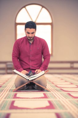 Dindar Müslüman adam caminin içinde dua ediyor.