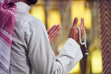 Dindar Müslüman adam caminin içinde dua ediyor.