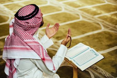 Dindar Müslüman adam caminin içinde dua ediyor.