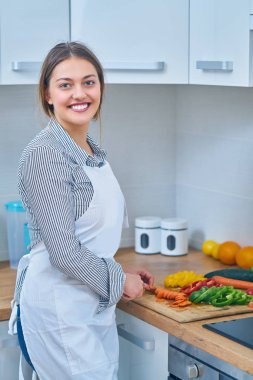 Portre sağlıklı meyve suyu evde kendini göstermek için bazı meyve ve sebze kesme genç bir kadın