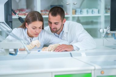 Takma diş, ağız hijyeni. Takma diş, takma diş, bir çalışma ve diş araçları içeren bir tablo üzerinde çalışırken protez eller.