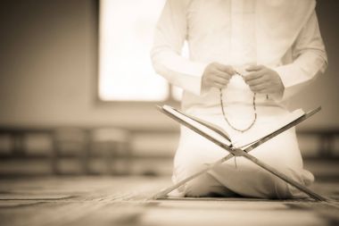 Dindar Müslüman adam caminin içinde dua ediyor.