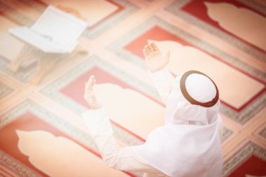 Dindar Müslüman adam caminin içinde dua ediyor.