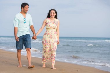 Kumsalda yürüyen çift.