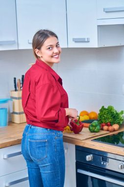 Portre sağlıklı meyve suyu evde kendini göstermek için bazı meyve ve sebze kesme genç bir kadın