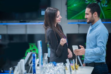 tüketici elektroniği genç bir çift satın almak en son dizüstü bilgisayar, televizyon ve fotoğraf kamera seyir saklamak