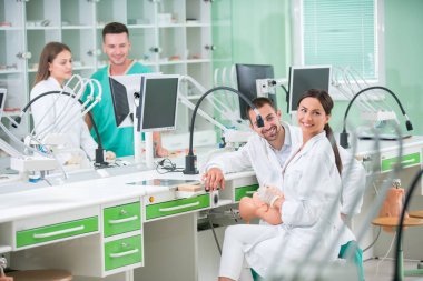 Takma diş, ağız hijyeni. Takma diş, takma diş, bir çalışma ve diş araçları içeren bir tablo üzerinde çalışırken protez eller.