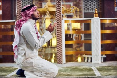 Dindar Müslüman adam caminin içinde dua ediyor.