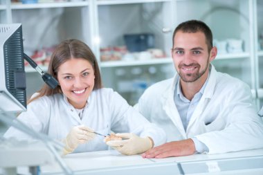 Takma diş, ağız hijyeni. Takma diş, takma diş, bir çalışma ve diş araçları içeren bir tablo üzerinde çalışırken protez eller.