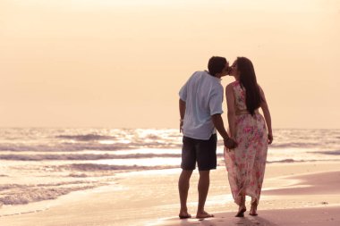 Kumsalda yürüyen çift.