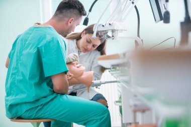 Takma diş, ağız hijyeni. Takma diş, takma diş, bir çalışma ve diş araçları içeren bir tablo üzerinde çalışırken protez eller.