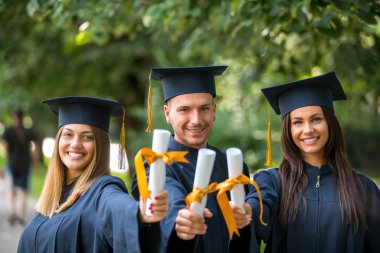 Eğitim, mezuniyet, insanlar kavramı - harç panoları ve bekarlığa veda önlük diploma ile mutlu uluslararası öğrenci grubu