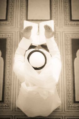 Dindar Müslüman adam caminin içinde dua ediyor.