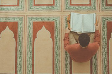 Dindar Müslüman adam caminin içinde dua ediyor.