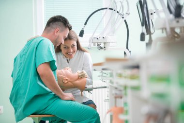 Takma diş, ağız hijyeni. Takma diş, takma diş, bir çalışma ve diş araçları içeren bir tablo üzerinde çalışırken protez eller.